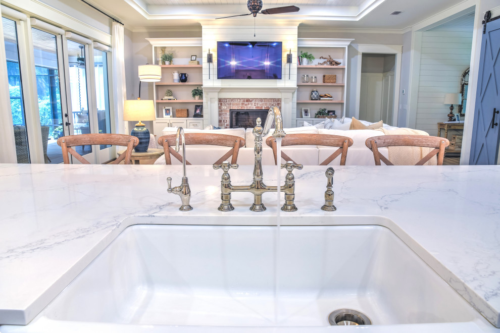 Esempio di una cucina stile marinaro di medie dimensioni con lavello stile country, top in marmo e top bianco