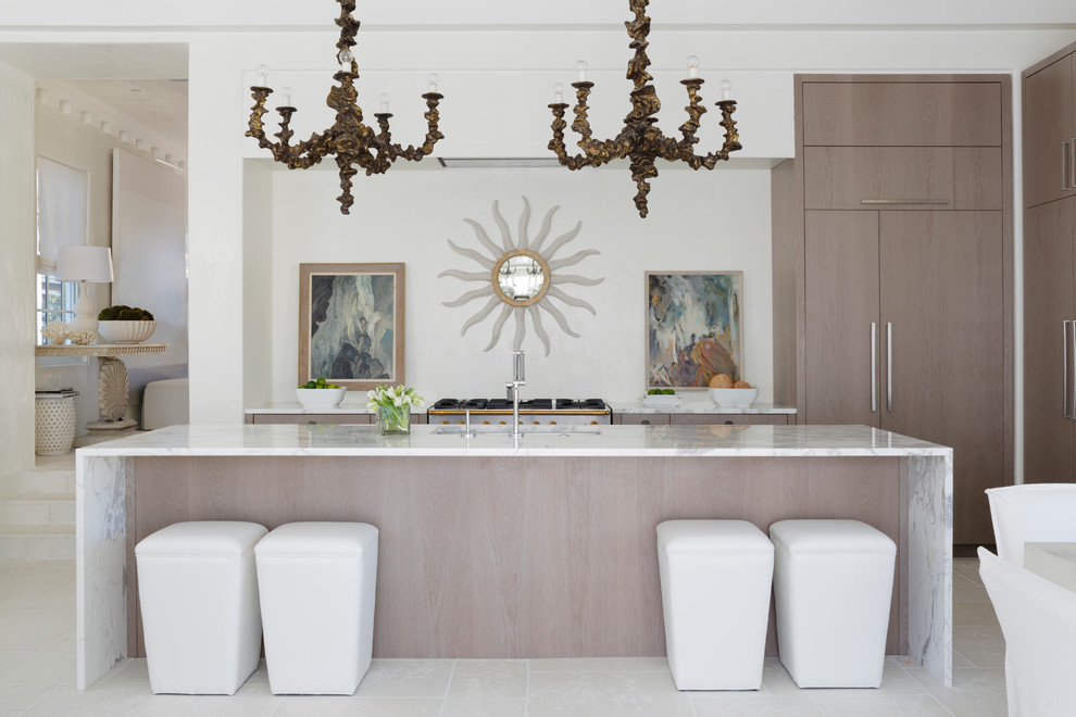 Immagine di un cucina con isola centrale costiero con lavello sottopiano, ante lisce e ante in legno chiaro