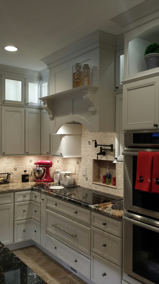 Example of a huge classic l-shaped travertine floor eat-in kitchen design in Other with an undermount sink, recessed-panel cabinets, white cabinets, laminate countertops, beige backsplash, stone tile backsplash, stainless steel appliances and an island