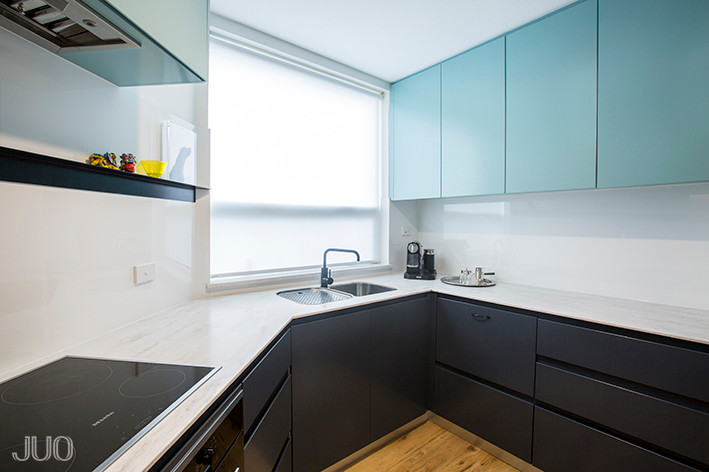 This is an example of a small contemporary u-shaped enclosed kitchen in Perth with a submerged sink, flat-panel cabinets, blue cabinets, composite countertops, white splashback, glass sheet splashback, stainless steel appliances, vinyl flooring and no island.