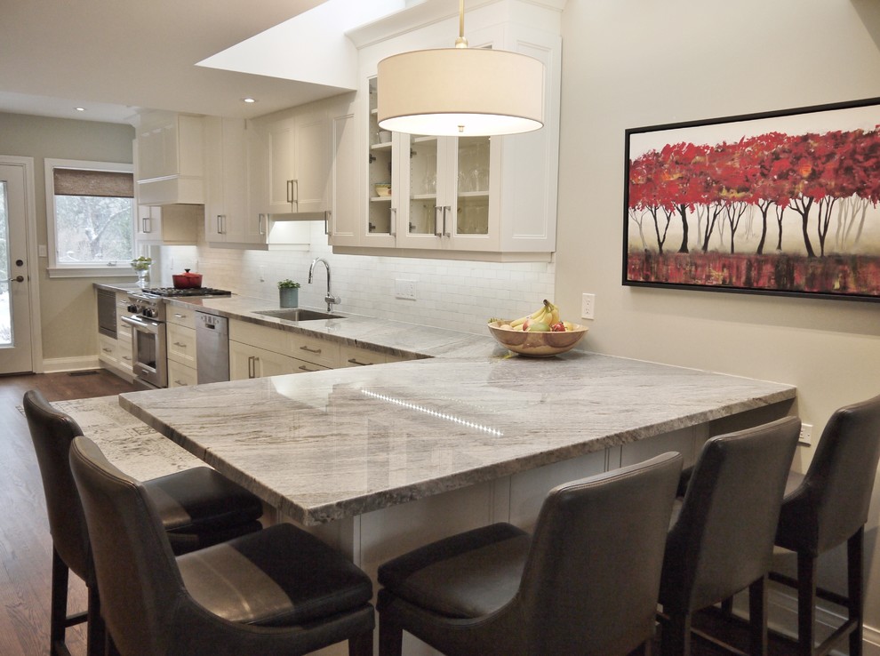 Mid-sized transitional l-shaped medium tone wood floor enclosed kitchen photo in Toronto with an undermount sink, recessed-panel cabinets, white cabinets, quartzite countertops, white backsplash, marble backsplash and stainless steel appliances