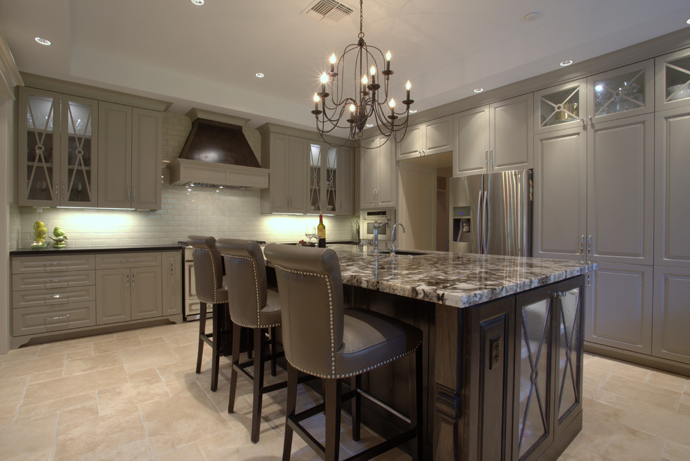 Inspiration for a large transitional u-shaped travertine floor open concept kitchen remodel in Houston with an undermount sink, glass-front cabinets, gray cabinets, granite countertops, gray backsplash, ceramic backsplash, stainless steel appliances and an island