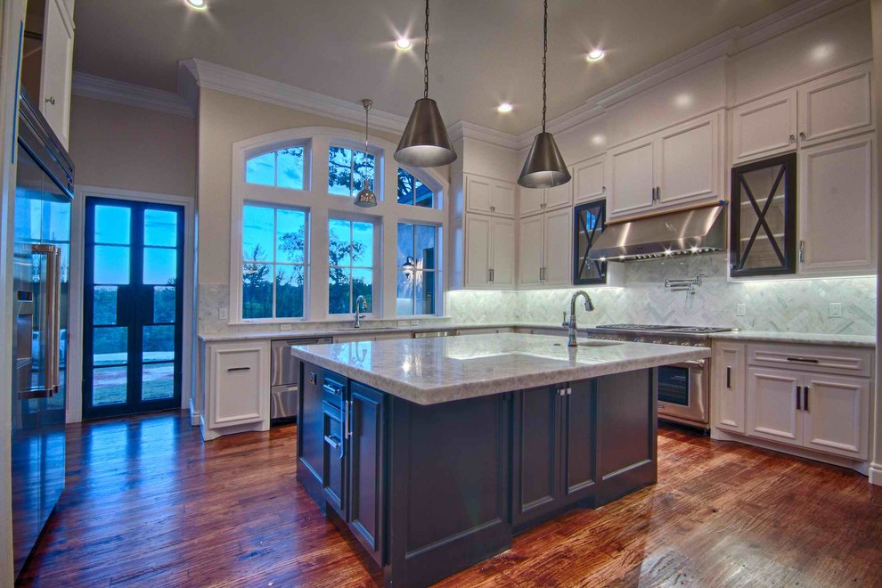 Mittelgroße Klassische Wohnküche in L-Form mit weißen Schränken, Granit-Arbeitsplatte, Küchengeräten aus Edelstahl, hellem Holzboden und Kücheninsel in San Diego