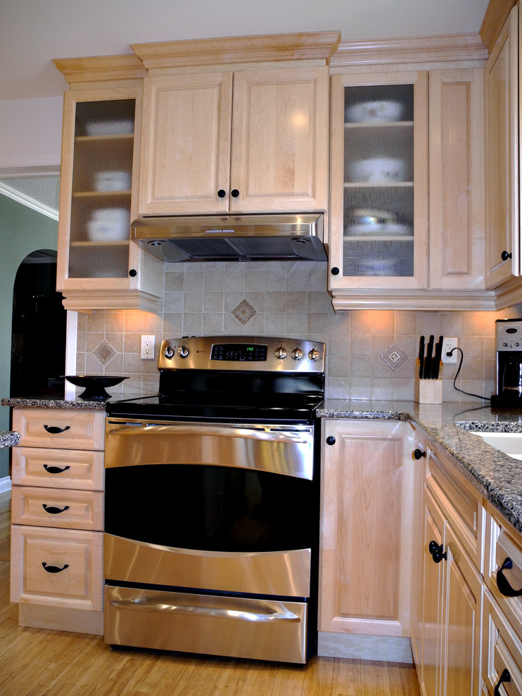 Inredning av ett modernt mellanstort kök, med en undermonterad diskho, luckor med profilerade fronter, skåp i ljust trä, granitbänkskiva, grått stänkskydd, stänkskydd i keramik, rostfria vitvaror, ljust trägolv och en köksö