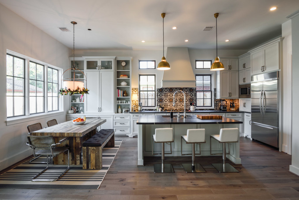 Classic kitchen in Houston with a double-bowl sink, shaker cabinets, white cabinets, soapstone worktops, multi-coloured splashback, stainless steel appliances, dark hardwood flooring and an island.