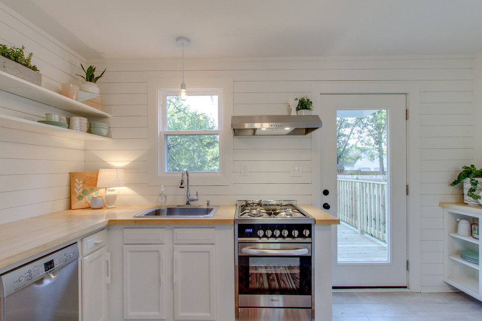 Idéer för att renovera ett litet funkis kök, med en nedsänkt diskho, skåp i shakerstil, vita skåp, träbänkskiva, vitt stänkskydd, stänkskydd i trä, rostfria vitvaror, ljust trägolv och vitt golv