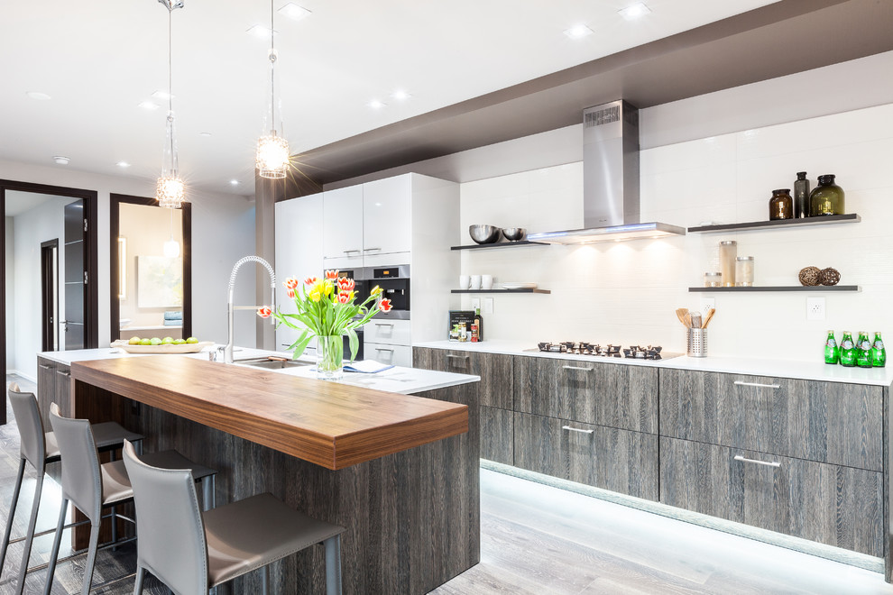 This is an example of a contemporary galley kitchen in Seattle with a submerged sink, flat-panel cabinets, dark wood cabinets, wood worktops, white splashback and an island.