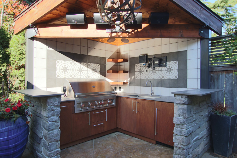Modern inredning av ett litet brun brunt kök, med en undermonterad diskho, släta luckor, skåp i mörkt trä, flerfärgad stänkskydd, stänkskydd i keramik, rostfria vitvaror, betonggolv och gult golv