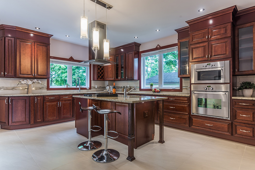 Example of a large trendy l-shaped porcelain tile kitchen pantry design in Montreal with an undermount sink, raised-panel cabinets, dark wood cabinets, granite countertops, multicolored backsplash, mosaic tile backsplash, stainless steel appliances and an island