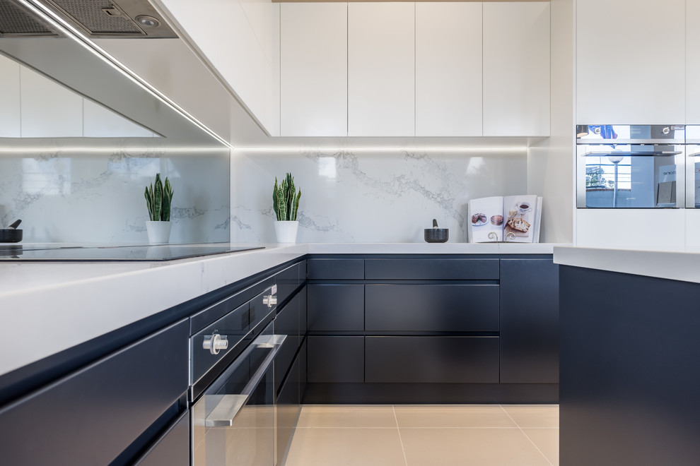 Exempel på ett avskilt, mellanstort modernt l-kök, med släta luckor, vita skåp, marmorbänkskiva, vitt stänkskydd, stänkskydd i marmor, svarta vitvaror och en köksö