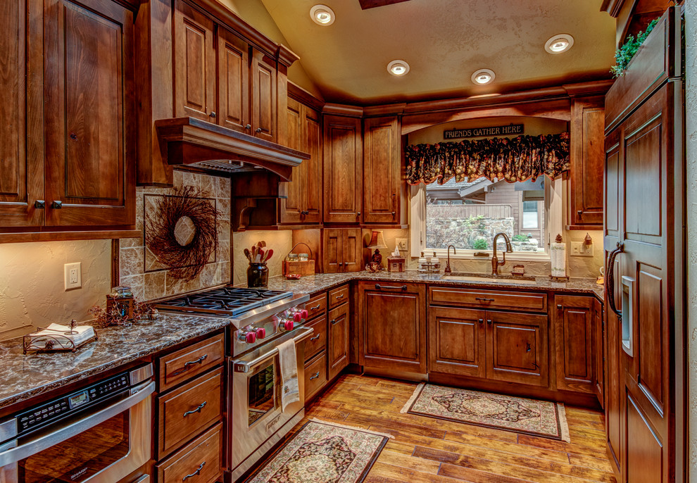 Mid-sized elegant u-shaped medium tone wood floor enclosed kitchen photo in Denver with an undermount sink, raised-panel cabinets, dark wood cabinets, granite countertops and stainless steel appliances