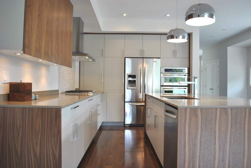 Moderne Küche mit Küchengeräten aus Edelstahl, Quarzwerkstein-Arbeitsplatte, flächenbündigen Schrankfronten und grauen Schränken in Ottawa