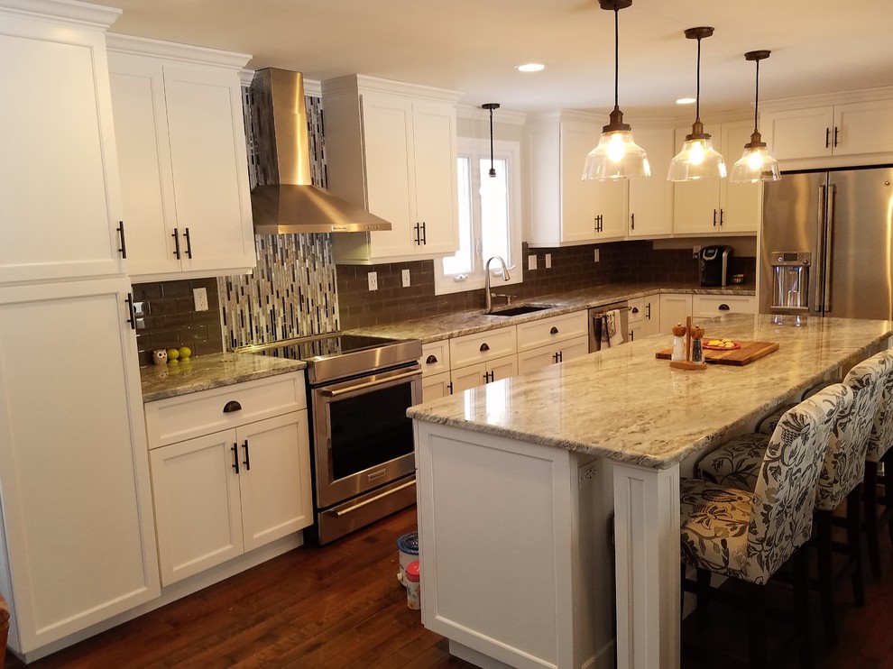 Idéer för att renovera ett stort vintage kök, med en undermonterad diskho, luckor med upphöjd panel, vita skåp, granitbänkskiva, brunt stänkskydd, stänkskydd i keramik, rostfria vitvaror, mellanmörkt trägolv, en köksö och brunt golv