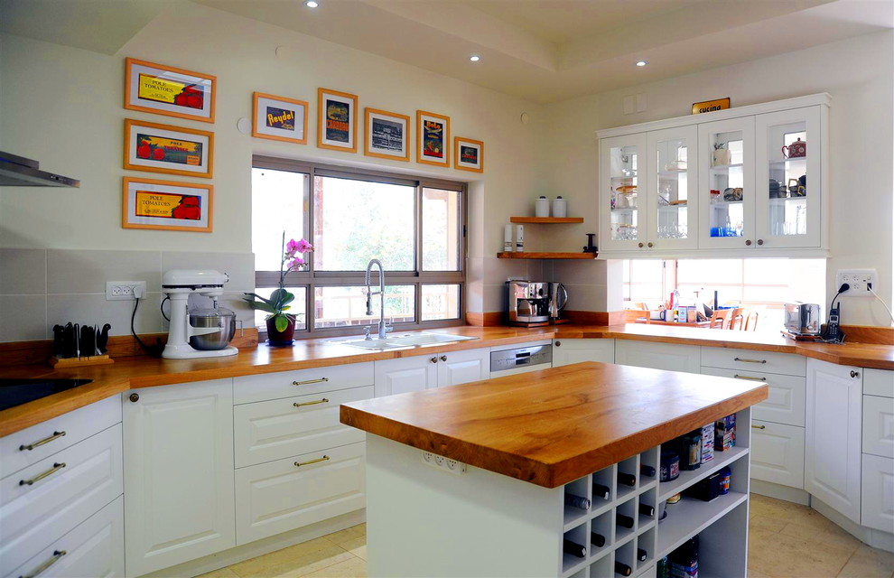 テルアビブにあるトラディショナルスタイルのおしゃれなキッチン (レイズドパネル扉のキャビネット、白いキャビネット、木材カウンター、グレーのキッチンパネル) の写真
