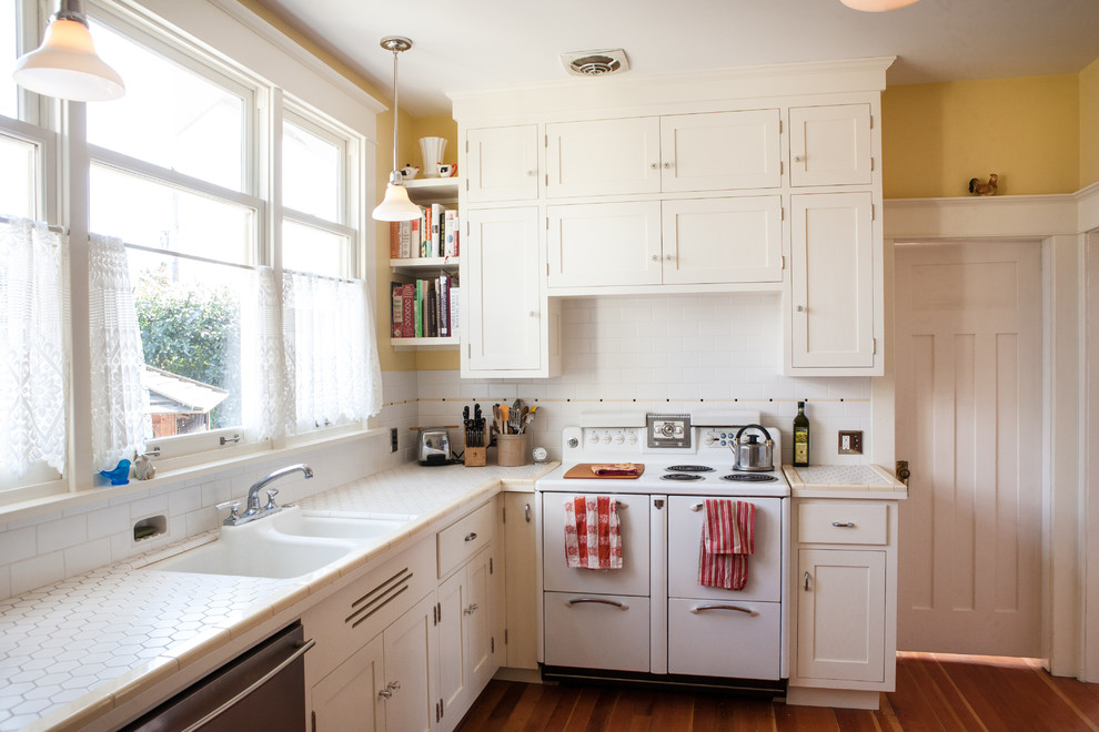 Exemple d'une cuisine chic avec plan de travail carrelé, une crédence blanche, une crédence en carrelage métro et un électroménager blanc.
