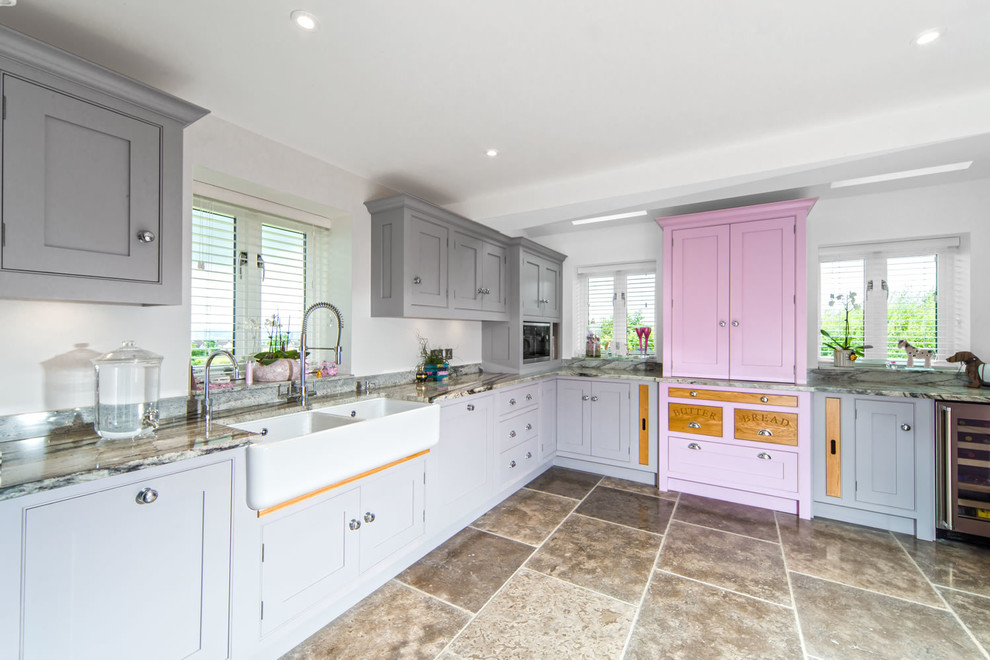 This is an example of a medium sized classic l-shaped kitchen in Other with a belfast sink, recessed-panel cabinets, marble worktops, stainless steel appliances, brown floors and grey worktops.