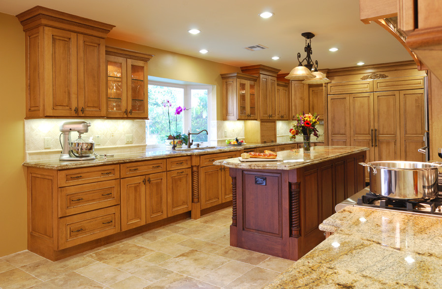 Bild på ett avskilt, stort medelhavsstil u-kök, med en dubbel diskho, luckor med infälld panel, skåp i mellenmörkt trä, beige stänkskydd, rostfria vitvaror och en köksö