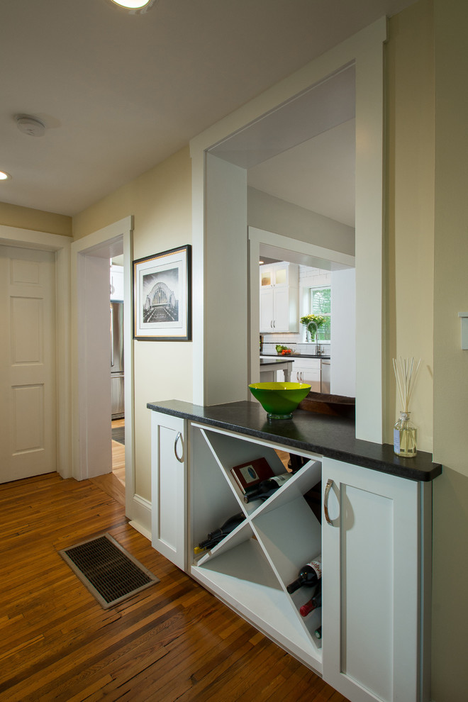 Medium sized classic l-shaped enclosed kitchen in Columbus with shaker cabinets, white cabinets, granite worktops, medium hardwood flooring, a submerged sink, white splashback, metro tiled splashback, stainless steel appliances and an island.