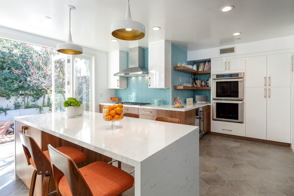 Inspiration for a large 1950s u-shaped cement tile floor and gray floor enclosed kitchen remodel in Los Angeles with an undermount sink, flat-panel cabinets, medium tone wood cabinets, quartzite countertops, blue backsplash, glass tile backsplash, stainless steel appliances and an island