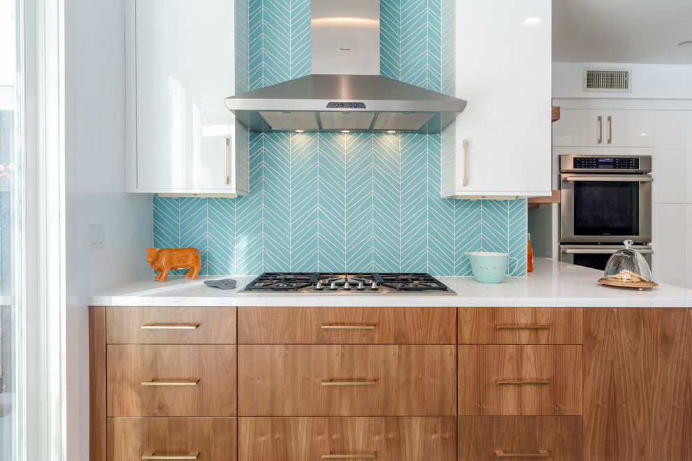 Inspiration for a large 1960s u-shaped cement tile floor and gray floor enclosed kitchen remodel in Los Angeles with an undermount sink, flat-panel cabinets, medium tone wood cabinets, quartzite countertops, blue backsplash, glass tile backsplash, stainless steel appliances and an island