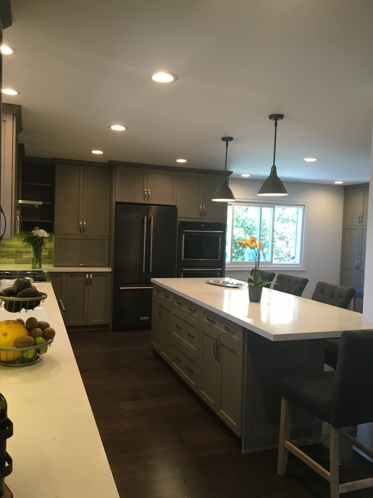 Photo of a medium sized traditional l-shaped open plan kitchen in Los Angeles with a single-bowl sink, recessed-panel cabinets, grey cabinets, grey splashback, stainless steel appliances, dark hardwood flooring and an island.