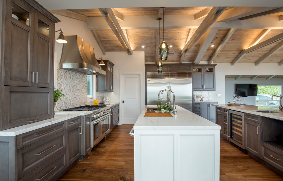 Inspiration for a large rural u-shaped open plan kitchen in Los Angeles with a submerged sink, recessed-panel cabinets, dark wood cabinets, quartz worktops, multi-coloured splashback, cement tile splashback, stainless steel appliances, medium hardwood flooring, an island and brown floors.