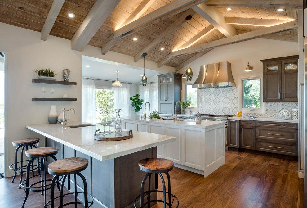 Design ideas for a large rural u-shaped open plan kitchen in Los Angeles with a submerged sink, recessed-panel cabinets, dark wood cabinets, quartz worktops, multi-coloured splashback, cement tile splashback, stainless steel appliances, medium hardwood flooring, an island and brown floors.