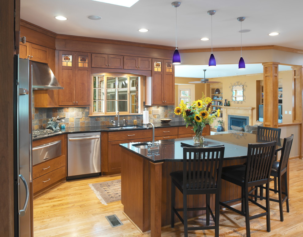 Inspiration for a large timeless l-shaped medium tone wood floor open concept kitchen remodel in Columbus with an undermount sink, shaker cabinets, medium tone wood cabinets, granite countertops, multicolored backsplash, ceramic backsplash, stainless steel appliances and an island