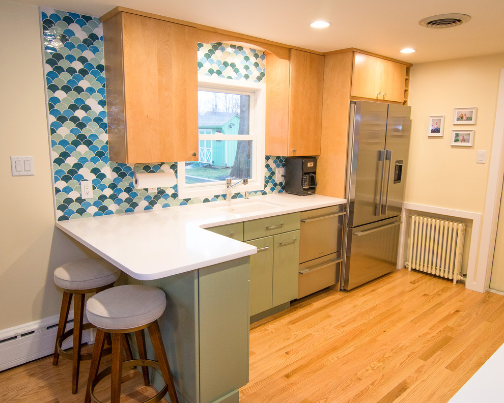 フィラデルフィアにあるお手頃価格の小さなコンテンポラリースタイルのおしゃれなキッチン (シングルシンク、緑のキャビネット、クオーツストーンカウンター、青いキッチンパネル、セラミックタイルのキッチンパネル、シルバーの調理設備、淡色無垢フローリング、茶色い床) の写真