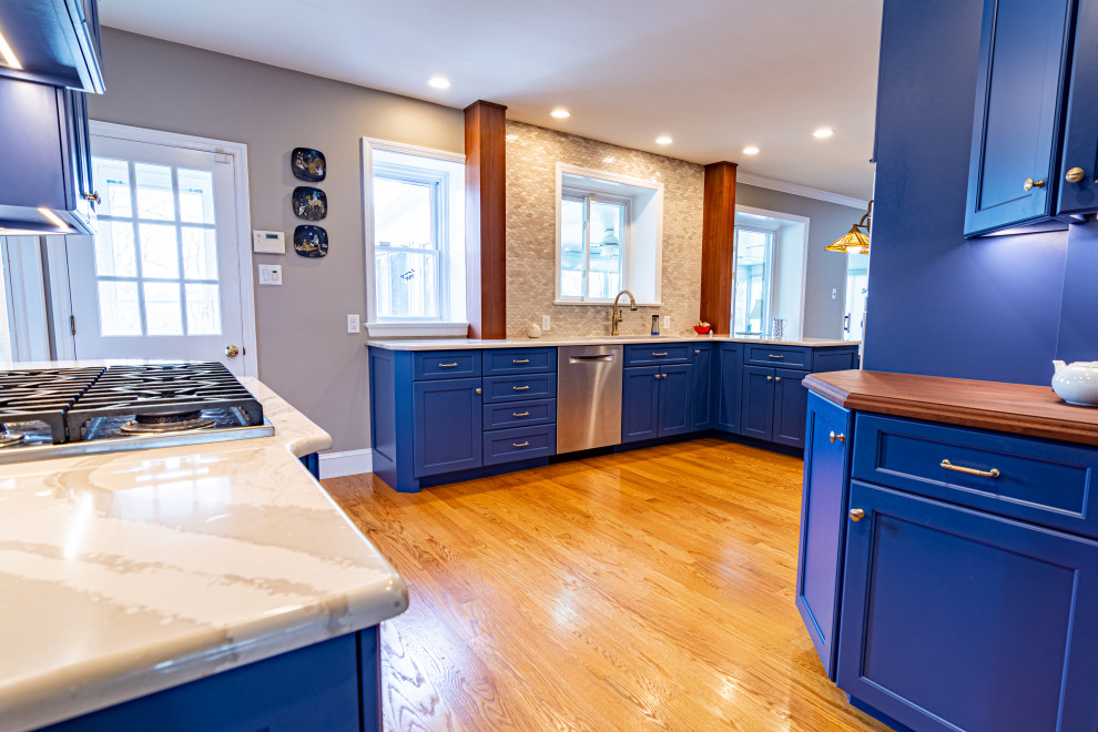 フィラデルフィアにあるラグジュアリーな広いトラディショナルスタイルのおしゃれなキッチン (シングルシンク、フラットパネル扉のキャビネット、青いキャビネット、クオーツストーンカウンター、ベージュキッチンパネル、ライムストーンのキッチンパネル、シルバーの調理設備、無垢フローリング、オレンジの床、白いキッチンカウンター) の写真