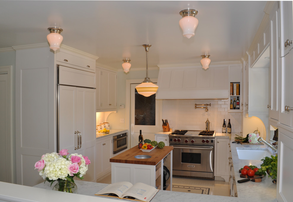 На фото: отдельная кухня в классическом стиле с фартуком из плитки кабанчик, врезной мойкой и мраморной столешницей