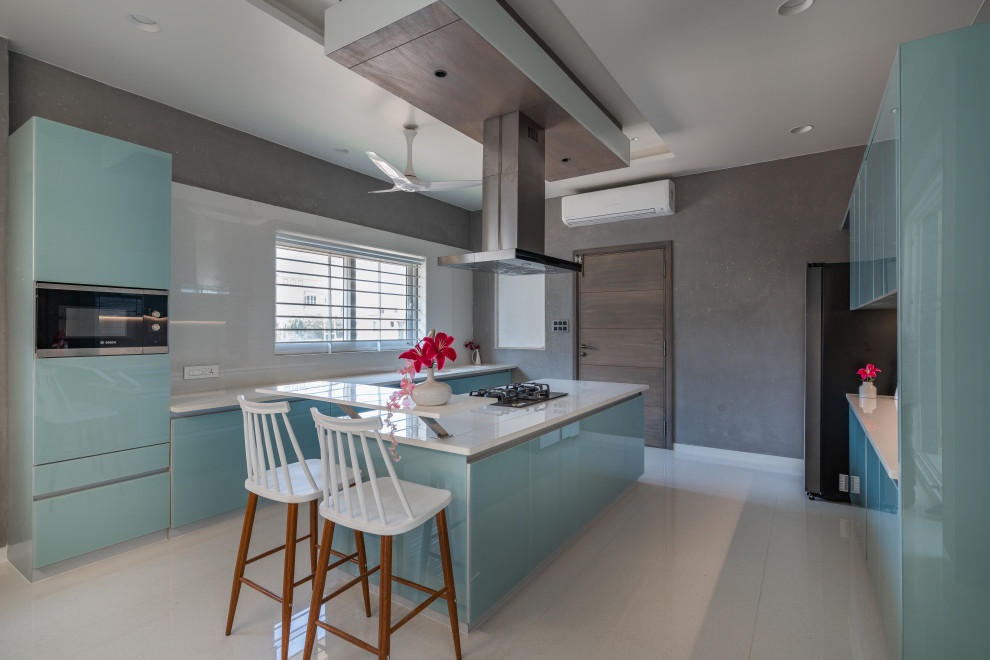 Esempio di una cucina minimal con ante lisce, ante blu, elettrodomestici in acciaio inossidabile, pavimento grigio e top bianco