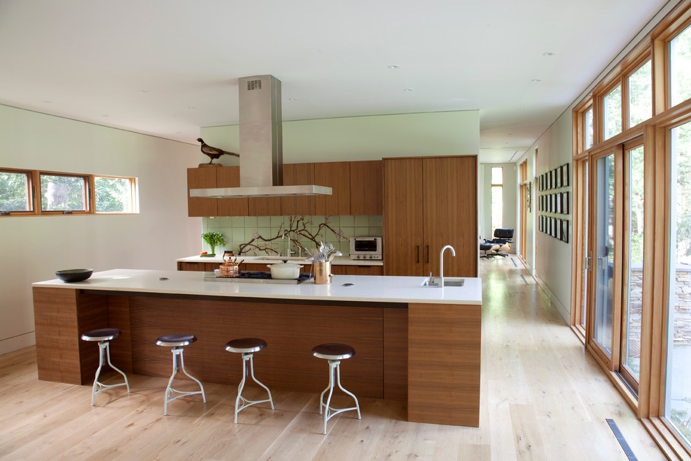 Inspiration for a contemporary galley kitchen remodel in New York with an undermount sink, flat-panel cabinets, medium tone wood cabinets, green backsplash and stainless steel appliances