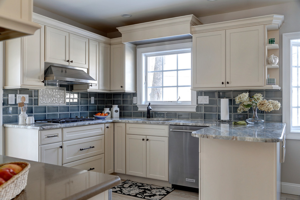 This is an example of a medium sized traditional u-shaped enclosed kitchen in New York with a submerged sink, shaker cabinets, beige cabinets, granite worktops, green splashback, metro tiled splashback, stainless steel appliances, vinyl flooring and a breakfast bar.