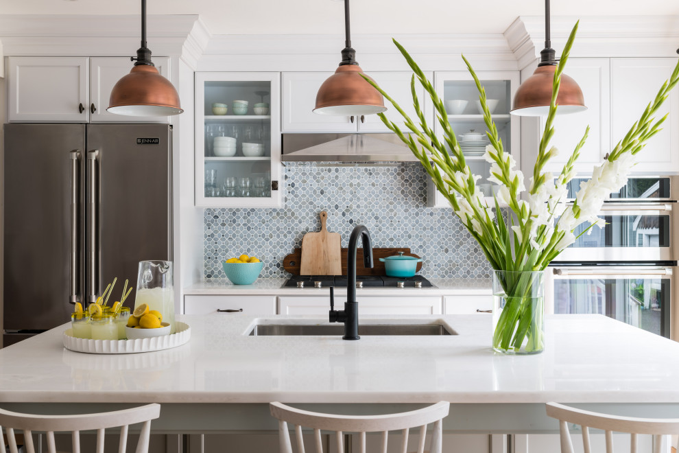 Immagine di una cucina parallela di medie dimensioni con ante in stile shaker, ante bianche, paraspruzzi blu, paraspruzzi con piastrelle in ceramica, elettrodomestici in acciaio inossidabile, parquet chiaro e top bianco