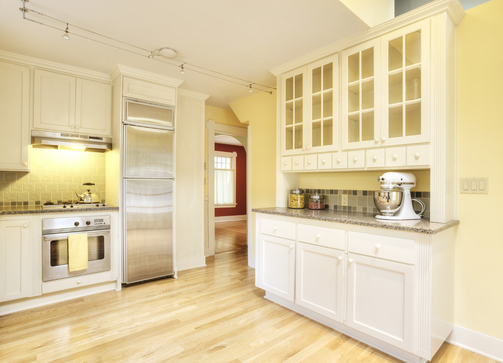 Источник вдохновения для домашнего уюта: кухня в классическом стиле с стеклянными фасадами, белыми фасадами, серым фартуком и техникой из нержавеющей стали