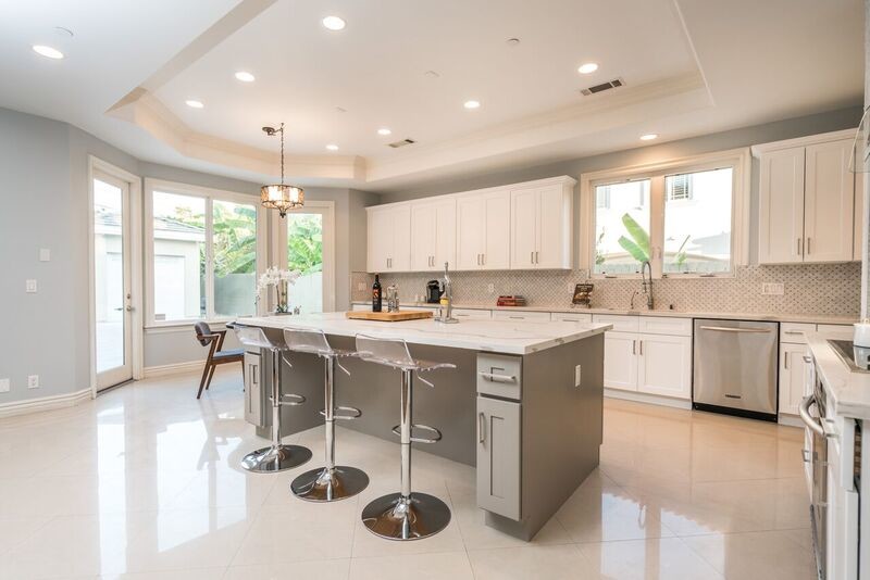 Idéer för att renovera ett mycket stort vintage kök med öppen planlösning, med en dubbel diskho, vita skåp, bänkskiva i kvarts, grått stänkskydd, stänkskydd i marmor, rostfria vitvaror, marmorgolv, en köksö och vitt golv