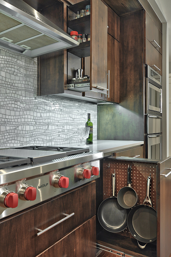 Modern inredning av ett mellanstort linjärt kök, med släta luckor, stänkskydd i mosaik, rostfria vitvaror, bänkskiva i kvarts, grått stänkskydd, mellanmörkt trägolv och skåp i mörkt trä