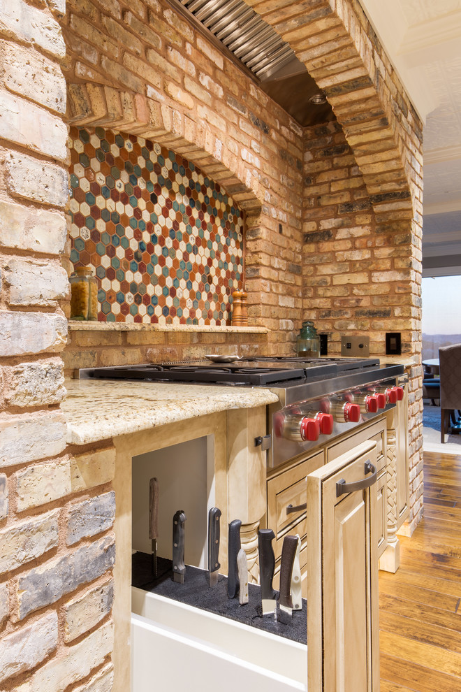 Exempel på ett stort klassiskt kök, med en undermonterad diskho, luckor med upphöjd panel, beige skåp, granitbänkskiva, beige stänkskydd, stänkskydd i stenkakel, integrerade vitvaror, mellanmörkt trägolv och en köksö
