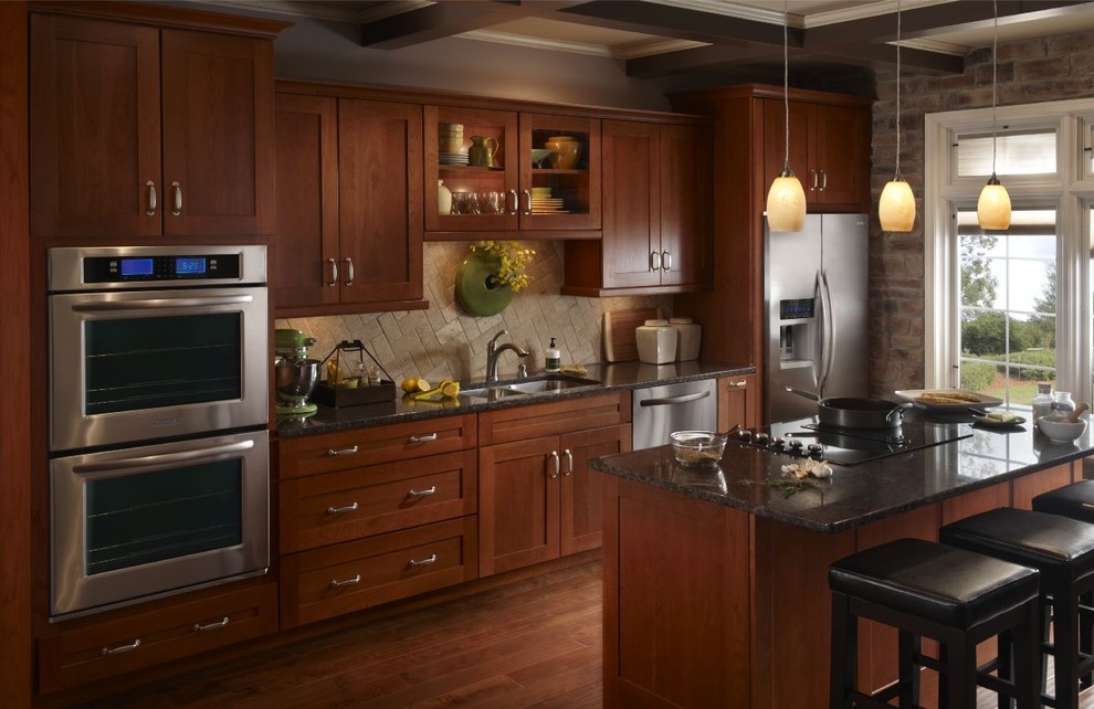 Exemple d'une cuisine craftsman en bois brun de taille moyenne avec un évier 2 bacs, un placard à porte shaker, un plan de travail en granite, un électroménager en acier inoxydable et un sol en bois brun.