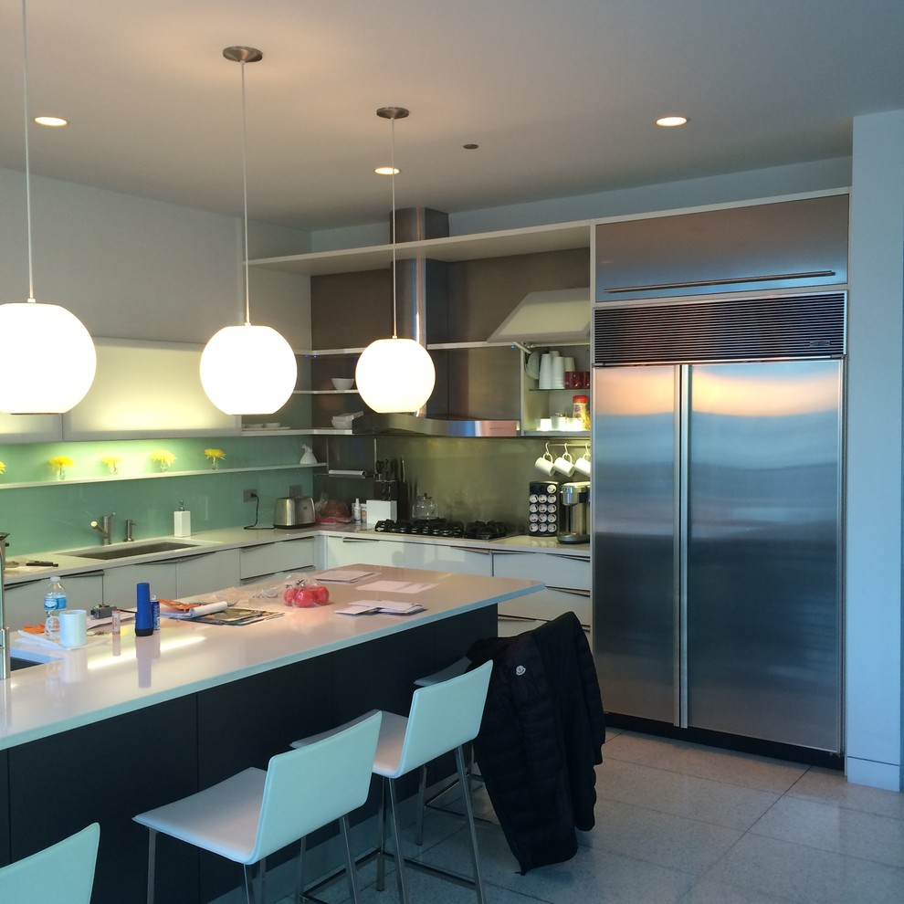 Example of a large minimalist l-shaped ceramic tile eat-in kitchen design in Chicago with an undermount sink, white cabinets, blue backsplash, stainless steel appliances and an island