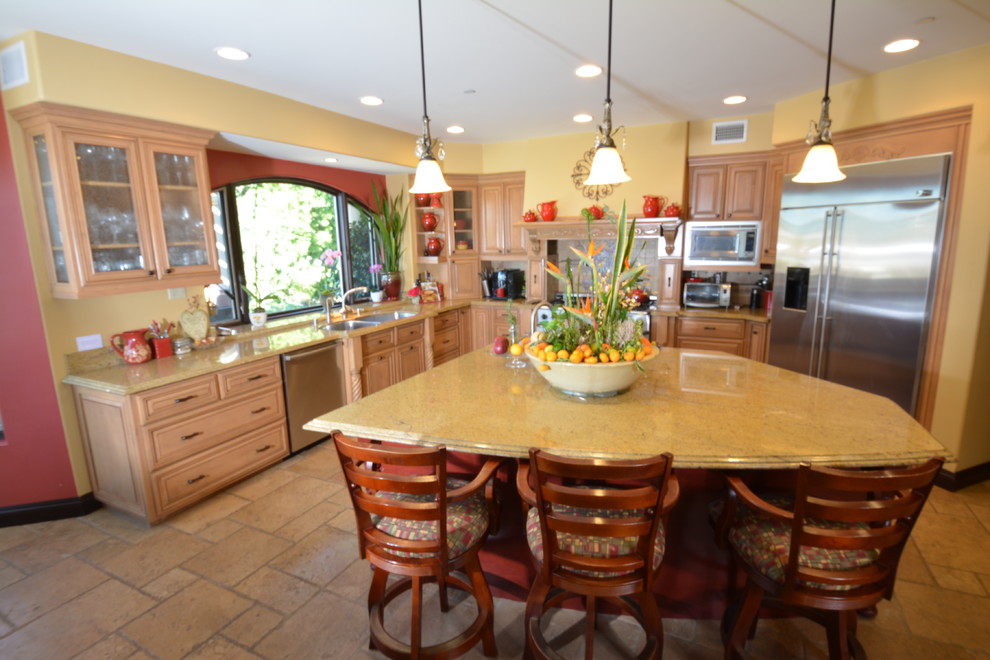 Exempel på ett stort medelhavsstil kök, med en undermonterad diskho, luckor med upphöjd panel, skåp i mellenmörkt trä, granitbänkskiva, rostfria vitvaror, travertin golv, en köksö och brunt golv