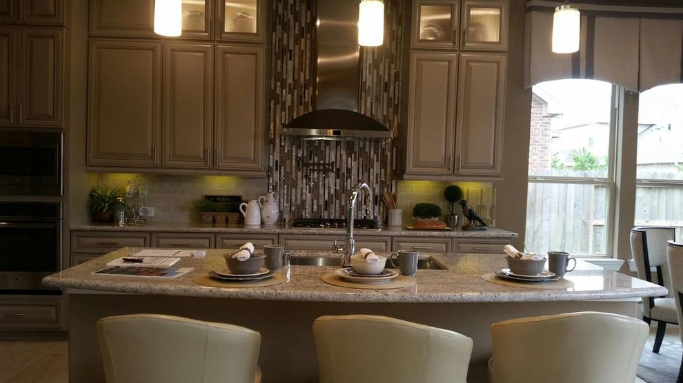 Exempel på ett mellanstort klassiskt kök, med en undermonterad diskho, luckor med upphöjd panel, beige skåp, granitbänkskiva, stänkskydd med metallisk yta, stänkskydd i stickkakel, rostfria vitvaror och en köksö