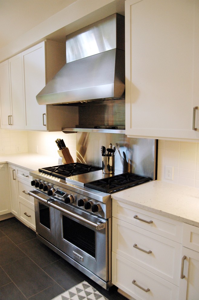 Exempel på ett klassiskt kök, med skåp i shakerstil, vita skåp, bänkskiva i kvarts, vitt stänkskydd, stänkskydd i tunnelbanekakel och rostfria vitvaror