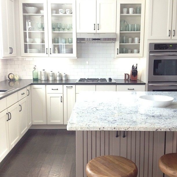 Example of a classic medium tone wood floor kitchen design in Baltimore with white cabinets, white backsplash, subway tile backsplash and stainless steel appliances