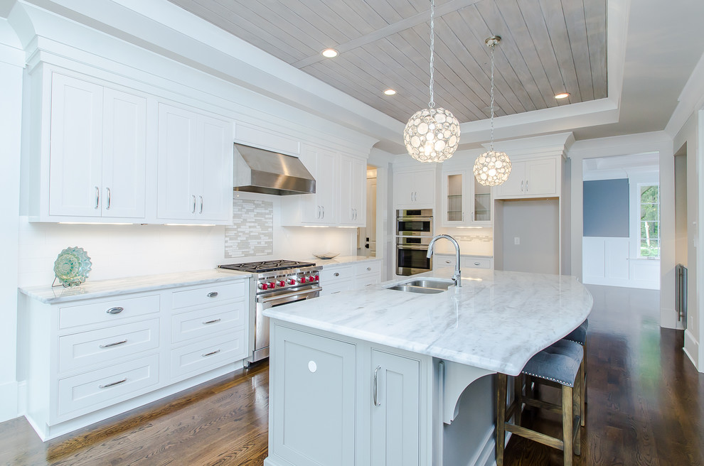 Eat-in kitchen - large farmhouse u-shaped dark wood floor and brown floor eat-in kitchen idea in Raleigh with an undermount sink, shaker cabinets, white cabinets, marble countertops, white backsplash, stainless steel appliances and an island