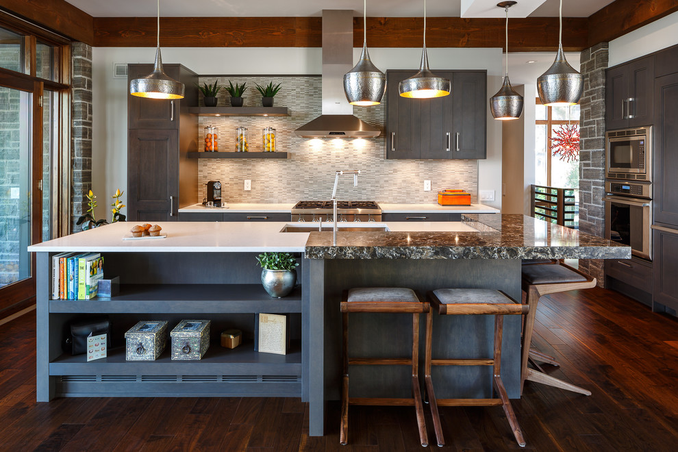 Mittelgroße Moderne Küche in U-Form mit Kücheninsel, Küchenrückwand in Grau, Küchengeräten aus Edelstahl, dunklem Holzboden, Unterbauwaschbecken, Schrankfronten mit vertiefter Füllung und blauen Schränken in Ottawa