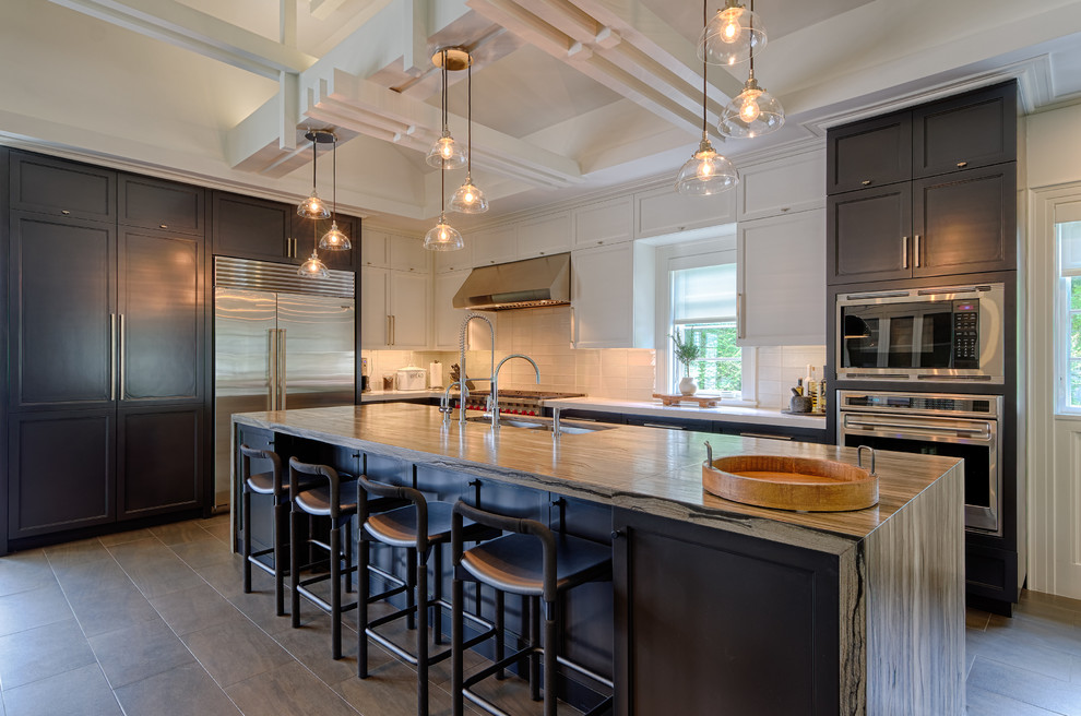 Eat-in kitchen - large transitional l-shaped slate floor and brown floor eat-in kitchen idea in New York with a double-bowl sink, shaker cabinets, white cabinets, white backsplash, glass tile backsplash, stainless steel appliances and an island