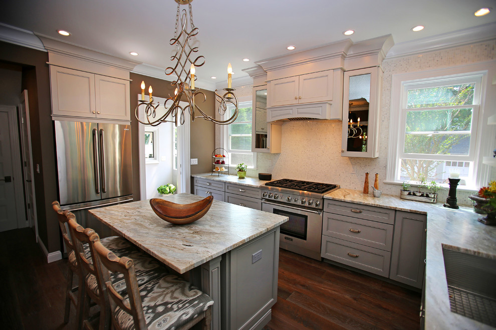 Exempel på ett avskilt, mellanstort klassiskt u-kök, med en enkel diskho, skåp i shakerstil, grå skåp, granitbänkskiva, vitt stänkskydd, stänkskydd i mosaik, rostfria vitvaror, mellanmörkt trägolv, en köksö och brunt golv
