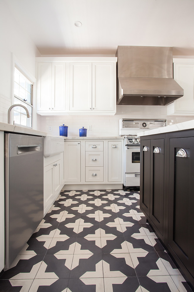 Modern inredning av ett avskilt, mellanstort l-kök, med en rustik diskho, luckor med profilerade fronter, vita skåp, bänkskiva i kvarts, vitt stänkskydd, stänkskydd i tunnelbanekakel, vita vitvaror, cementgolv, en köksö och svart golv